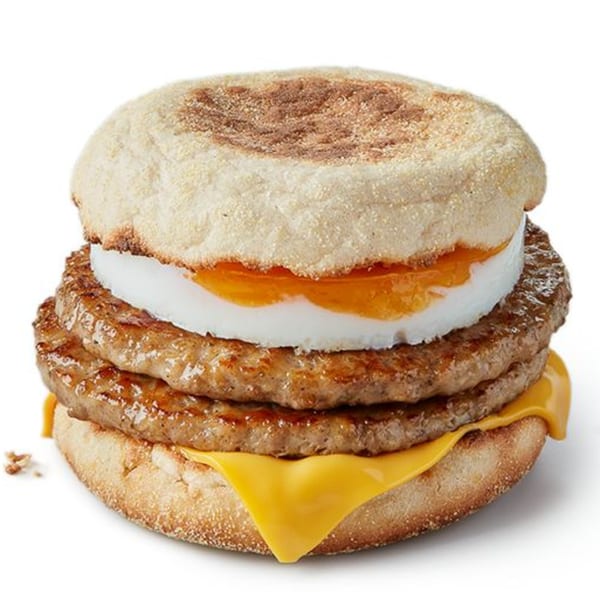 A McDonald's Double Sausage and Egg McMuffin with cheese on a white background.